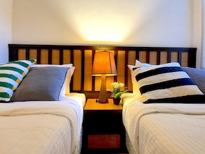 A hotel room with two beds, a nightstand with a lamp, and a small potted plant. - Gold Coast Morib - Sepang Water Themepark (Banting)