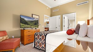 Une chambre d’hôtel avec un lit, une télévision, une armoire et une chaise.