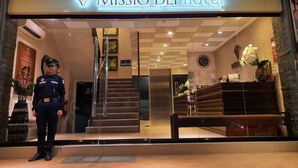 The entrance of Missio Dei Hotel with a reception desk, a staircase, and a security officer. - Missio Dei Hotel (Dipolog)