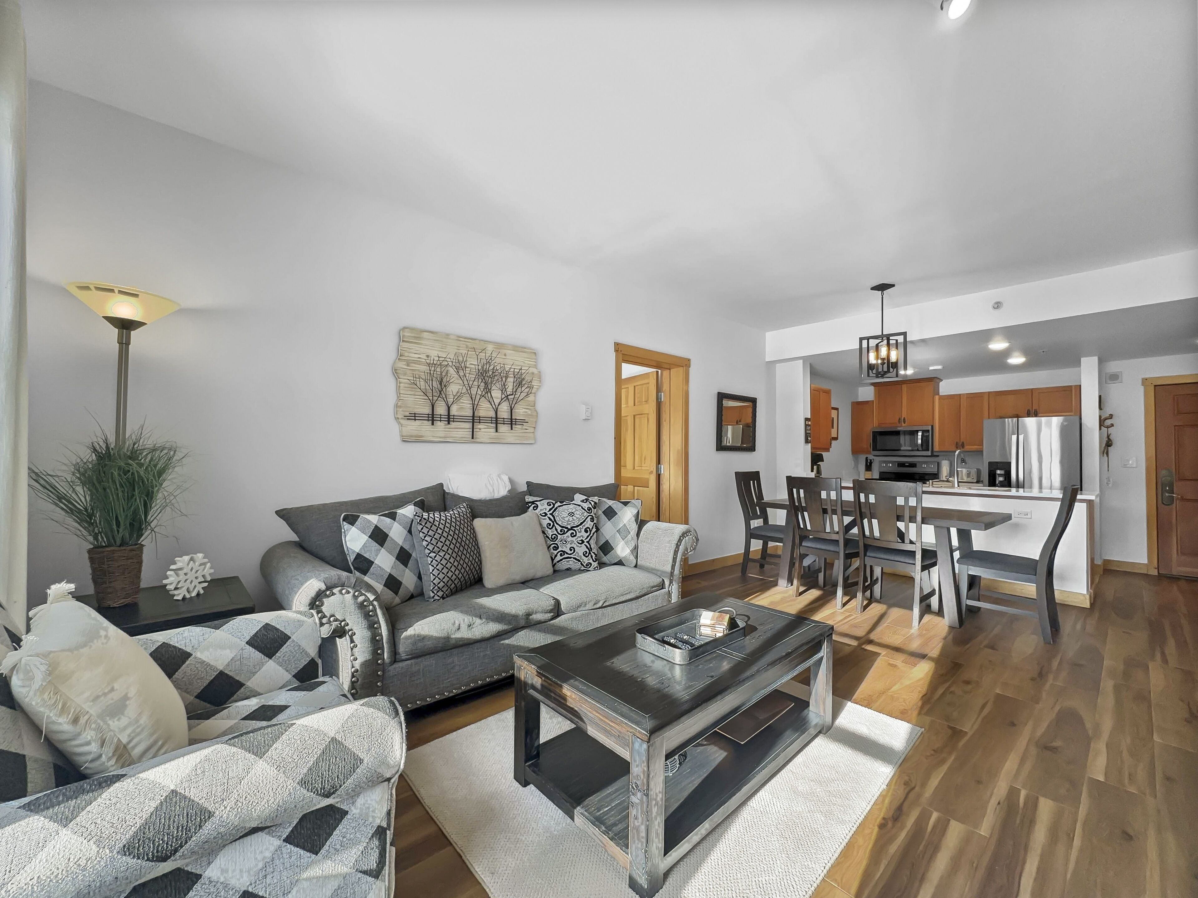 A modern living room with a sofa, coffee table, and dining area.