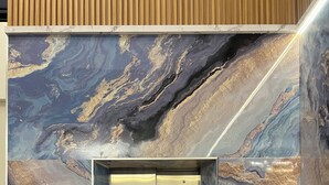 An elevator with a marble wall design. - Penuin Hotel (Batam)