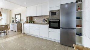 A modern kitchen with white cabinetry, a stainless steel refrigerator, a microwave, and an oven. - ☀Sun-flooded house / ☀ Panorama sea view & pool (Manilva)