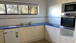 A kitchen with white cabinets, a dishwasher, a sink, and a microwave. - Bluecrest 2 at Blueys Beach (Blueys Beach)