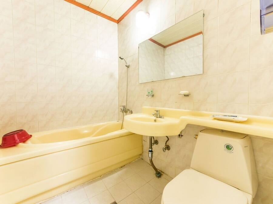 Un baño con bañera, lavabo e inodoro.