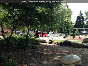 Explore a shaded outdoor space with play structures, a turtle sculpture, and picnic areas.