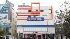 A hotel with a modern facade, signage for 'Mythri Hotel' and 'Capital Hotel', and a visible 'Federal Bank' branch. - Capital O 63727 Mythri Hotel (Hyderabad)