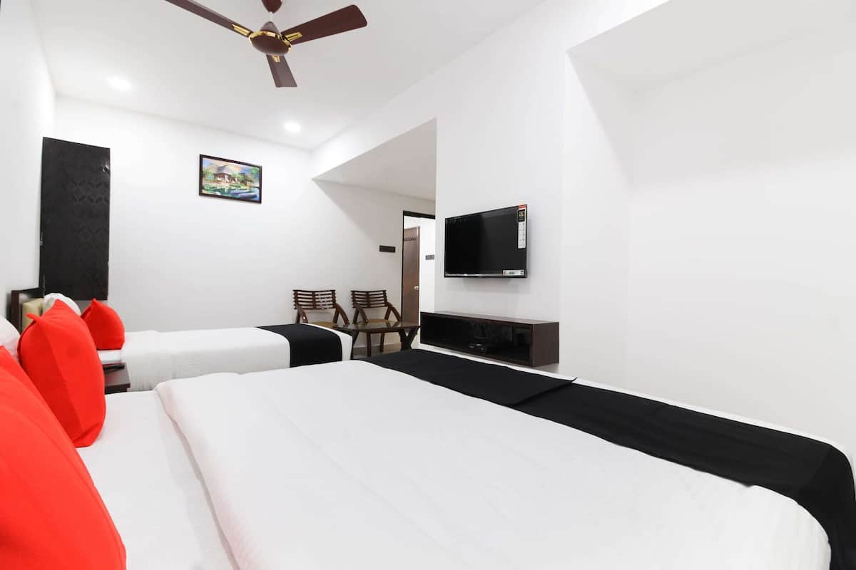 Hotelkamer met twee bedden, een plafondventilator, een flatscreen-tv en een schilderij aan de muur.
