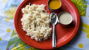 A red plate with shredded white food, two small bowls of yellow and white sauces, and a spoon on a table with a colorful tablecloth. - Capital O 63727 Mythri Hotel (Hyderabad)