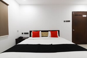 Ein Hotelzimmer mit Bett, Nachttisch, Kleiderschrank und einem Rauchverbot-Schild.