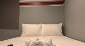 A hotel room with a bed, two pillows, and a folded towel on the bed. - Homeland Tourister's Apartelle Boracay (Boracay Island)