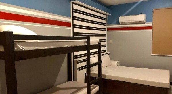 A bunk bed room with a white mattress, a wooden bunk, and a single bed. - Homeland Tourister's Apartelle Boracay (Boracay Island)