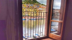 A room with a large window overlooking a river and colorful buildings.
