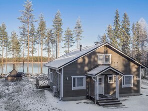 A cabin with a front porch, a chimney, and a deck area.