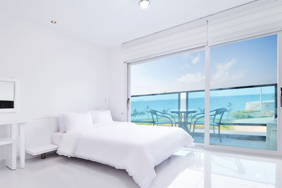 A modern bedroom with a large window overlooking a scenic view.