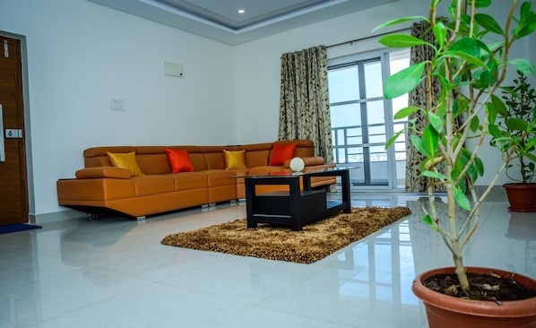 A modern living room with a sofa, a coffee table, and a potted plant.