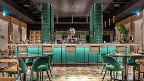 A bar area with a counter, stools, and a dining setup with tables and chairs. - HABITA79, Pompeii, a Tribute Portfolio Hotel (Pompei)