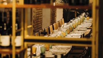 A wine rack with bottles and a long table set for dining.