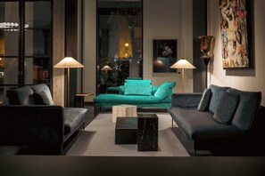 A modern living room with a teal sofa, two black armchairs, a marble coffee table, and two floor lamps. - HABITA79, Pompeii, a Tribute Portfolio Hotel (Pompei)
