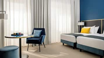 Una habitación de hotel con una cama, una silla, una mesa y una lámpara.
