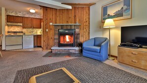 Ein Wohnzimmer mit Kamin, Fernseher und Sofa.