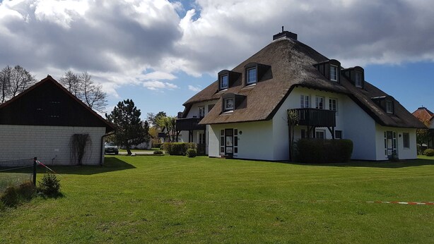 A large house with a steeply pitched roof, multiple windows, and a well-maintained lawn. - MeerZeit, Germany (Prerow)