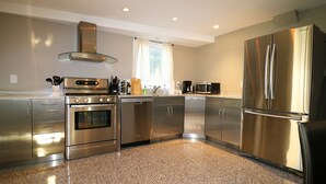A modern kitchen with stainless steel appliances, granite countertops, and a window with curtains. - BLISSFUL SPACIOUS HOME ⭐ IN HEART OF PRINCETON ⭐ (Princeton)