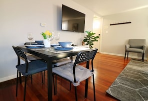 A dining area with a black table, blue chairs, and a grey rug. - BLISSFUL SPACIOUS HOME ⭐ IN HEART OF PRINCETON ⭐ (Princeton)