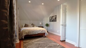 A bedroom with a bed, a nightstand, a lamp, a plant, and a door. - BLISSFUL SPACIOUS HOME ⭐ IN HEART OF PRINCETON ⭐ (Princeton)