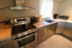 A modern kitchen with stainless steel appliances, a gas stove, oven, dishwasher, and a microwave. - BLISSFUL SPACIOUS HOME ⭐ IN HEART OF PRINCETON ⭐ (Princeton)