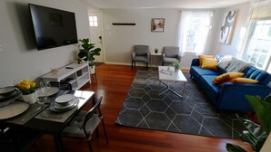 A modern living room with a blue sofa, dining table, and chairs. - BLISSFUL SPACIOUS HOME ⭐ IN HEART OF PRINCETON ⭐ (Princeton)