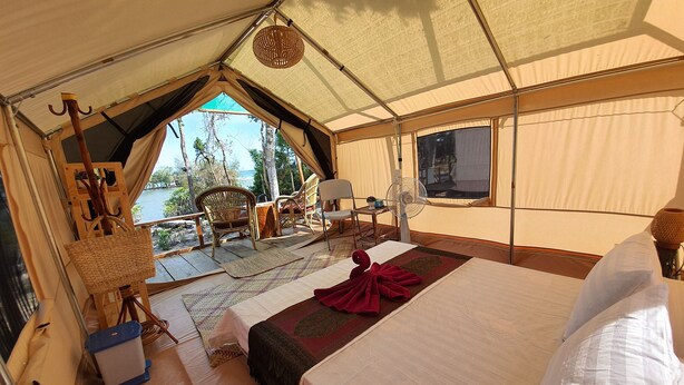 A tented accommodation with a bed, a fan, and a view of the outdoors. - 4k Camp Koh Rong (Koh Rong)