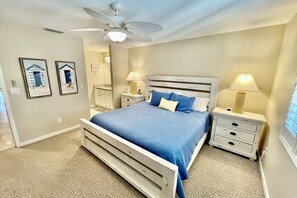 A bedroom with a bed, nightstands, a ceiling fan, and framed pictures on the wall. - VDP 59 - Relax and enjoy your vacation in this Gold-rated condo overlooking the pool. (Saint Augustine)