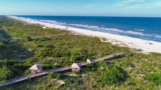 Une zone côtière dotée d’une promenade en bois, d’une plage et donnant sur l’océan.