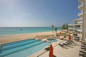 A pool area with a view of the beach and ocean.