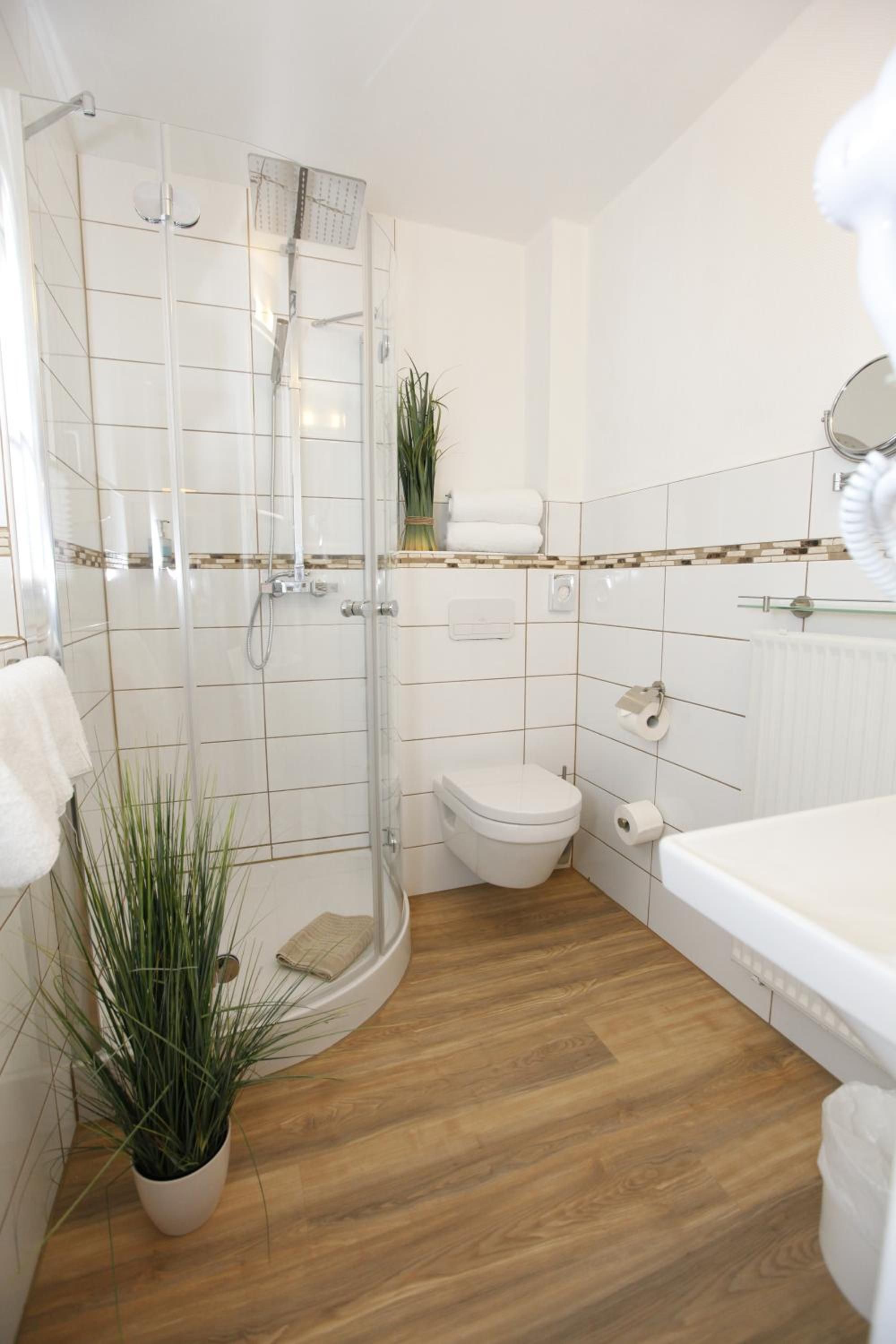 Ein modernes Badezimmer mit Duschkabine aus Glas, Toilette und Badewanne.