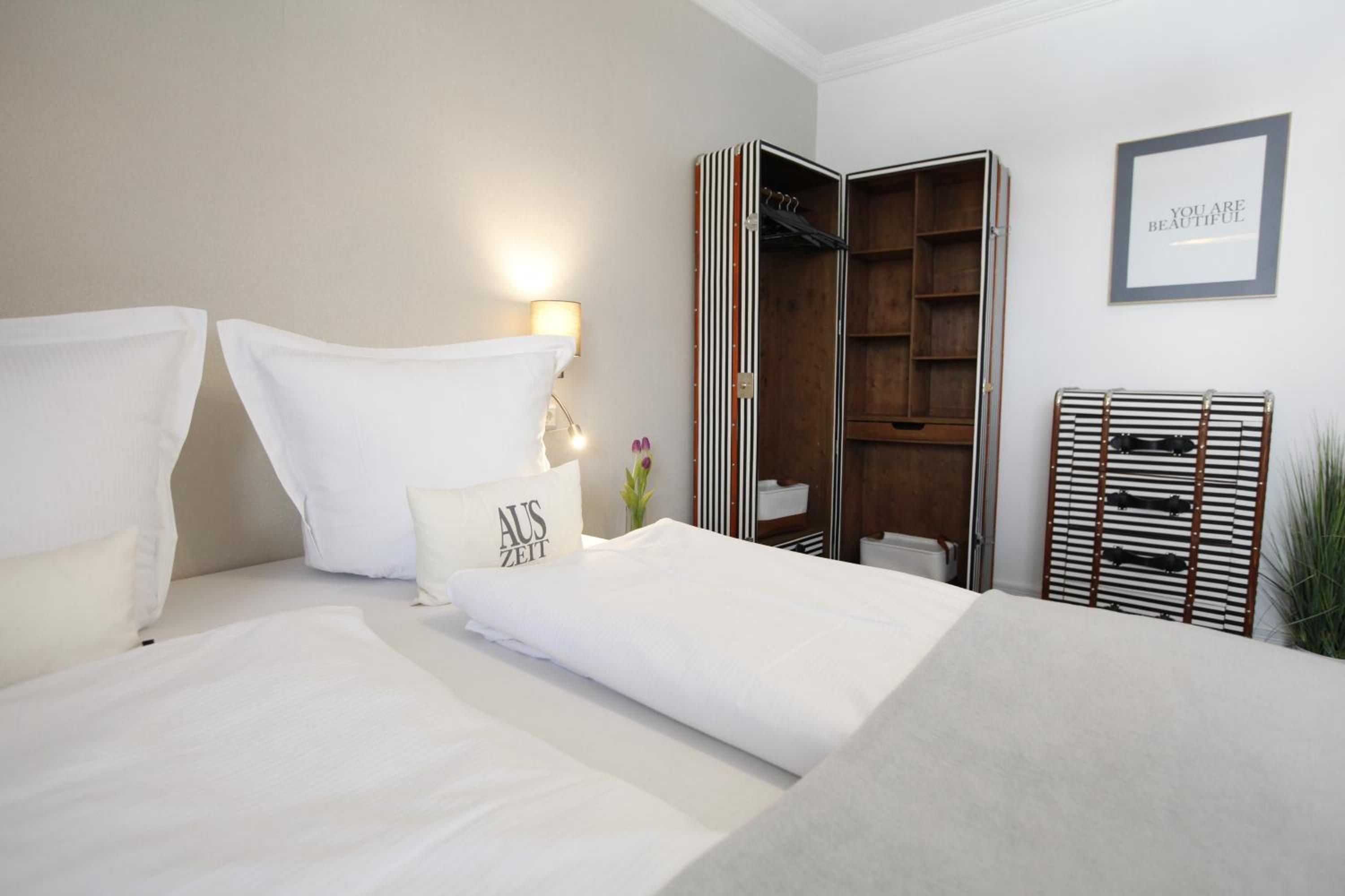 Une chambre d’hôtel avec un lit, une armoire et une citation inspirante encadrée accrochée au mur.