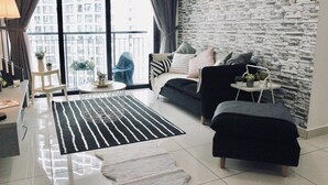 Ein modernes Wohnzimmer mit Steinwand, einer Couch, einem Couchtisch und Blick auf ein Hochhaus.
