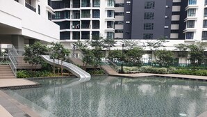 Ein modernes Gebäude mit Schwimmbad, einer geschwungenen Treppe und umgebender Bepflanzung.