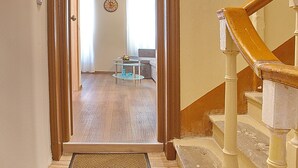 A wooden staircase with a handrail leading to a room with a sofa and a coffee table. - Liston Suite Plaza (Corfu)