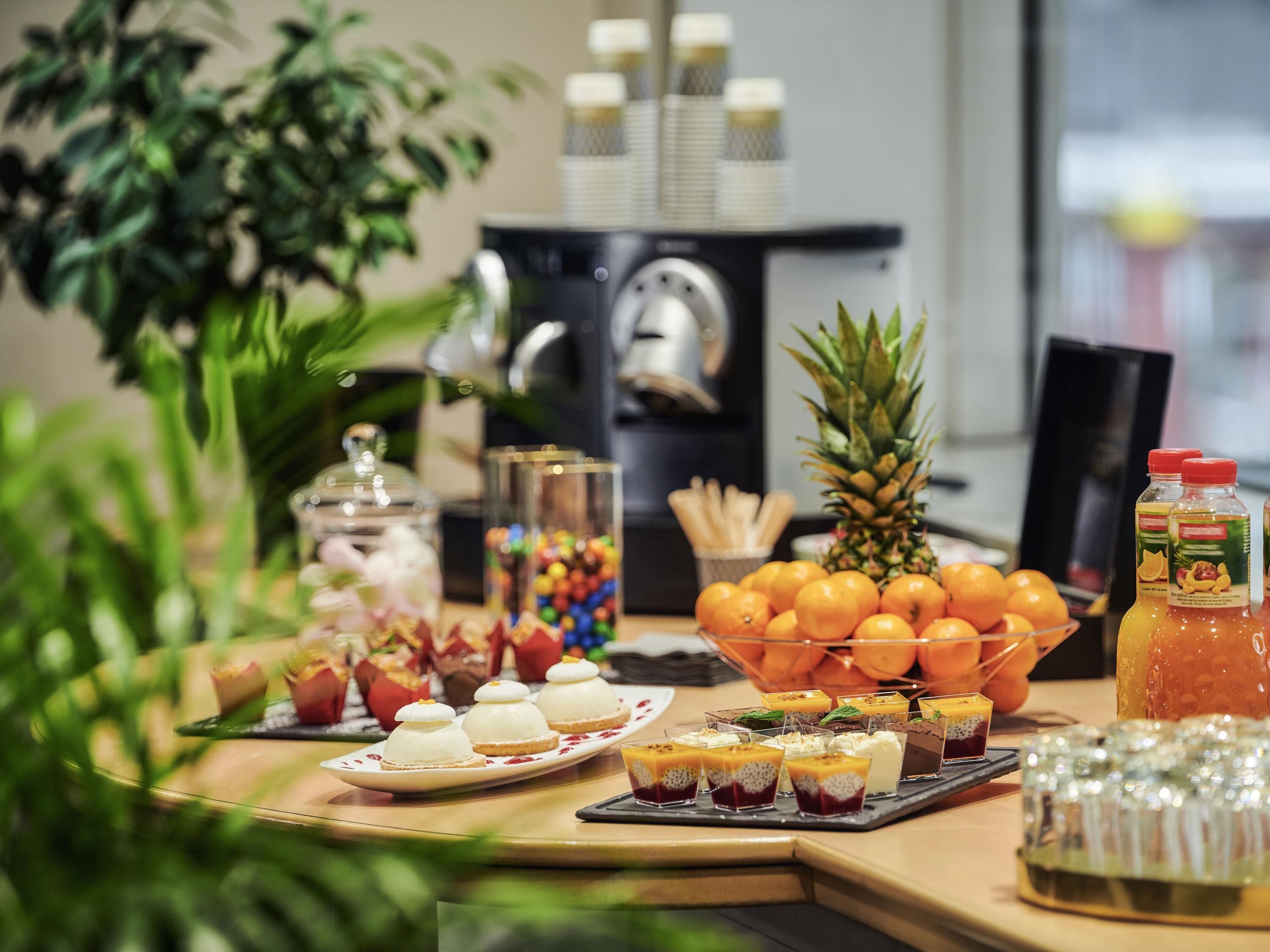 Ein Tisch mit verschiedenen Speisen, darunter eine Ananas, Orangen und eine Saftflasche.