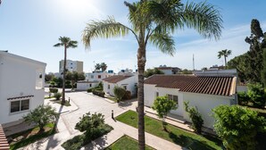 A residential area with white buildings, palm trees, and a clear sky. - Fig Tree Z Holiday Villas DPS09- Three Bed Bungalow (Protaras)