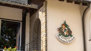 A building with a sign that reads "Nahrchenwald Wtenberg" and a decorative emblem featuring a figure and a tree.