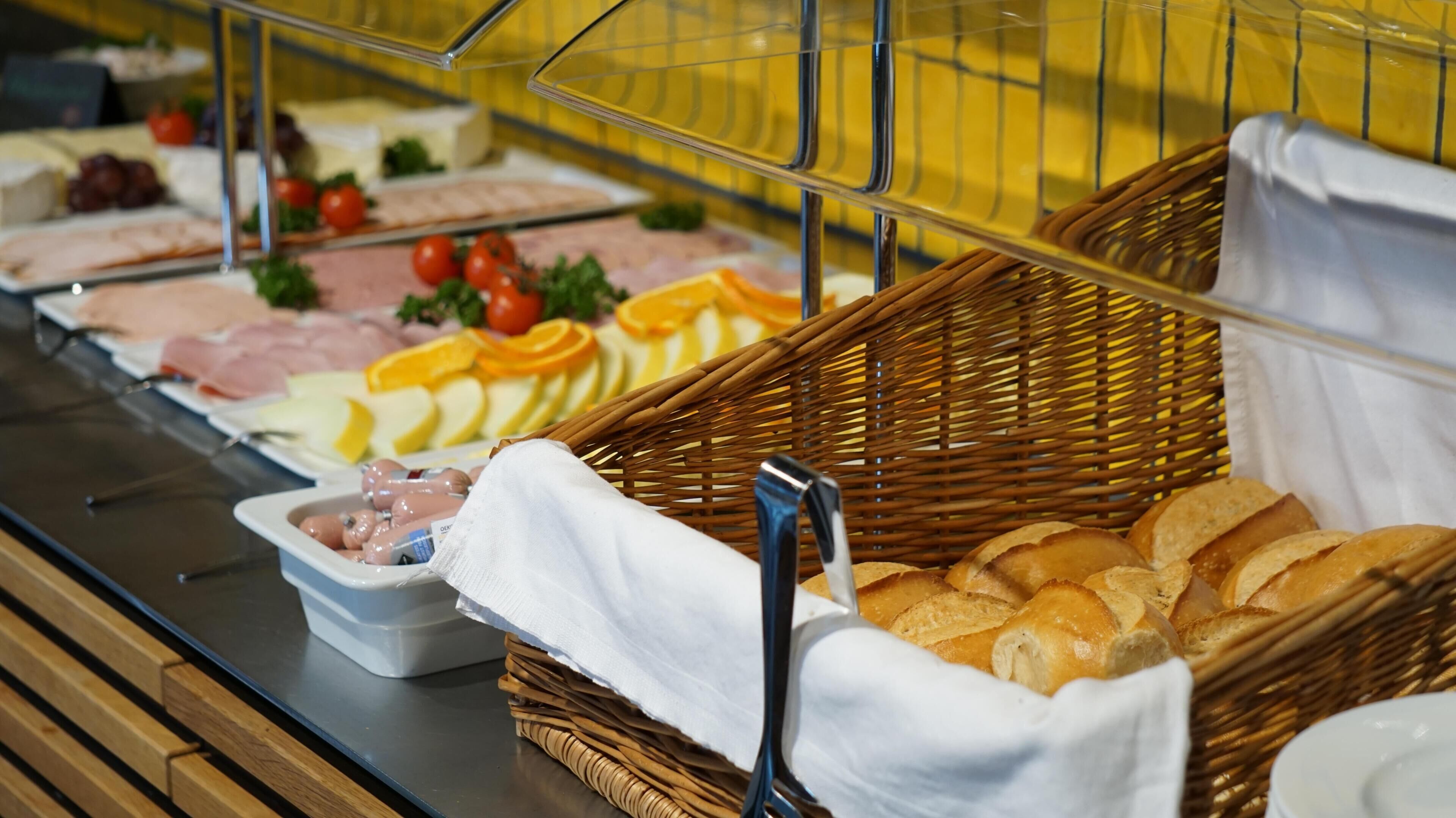 A buffet with various food items including meats, cheeses, and bread.