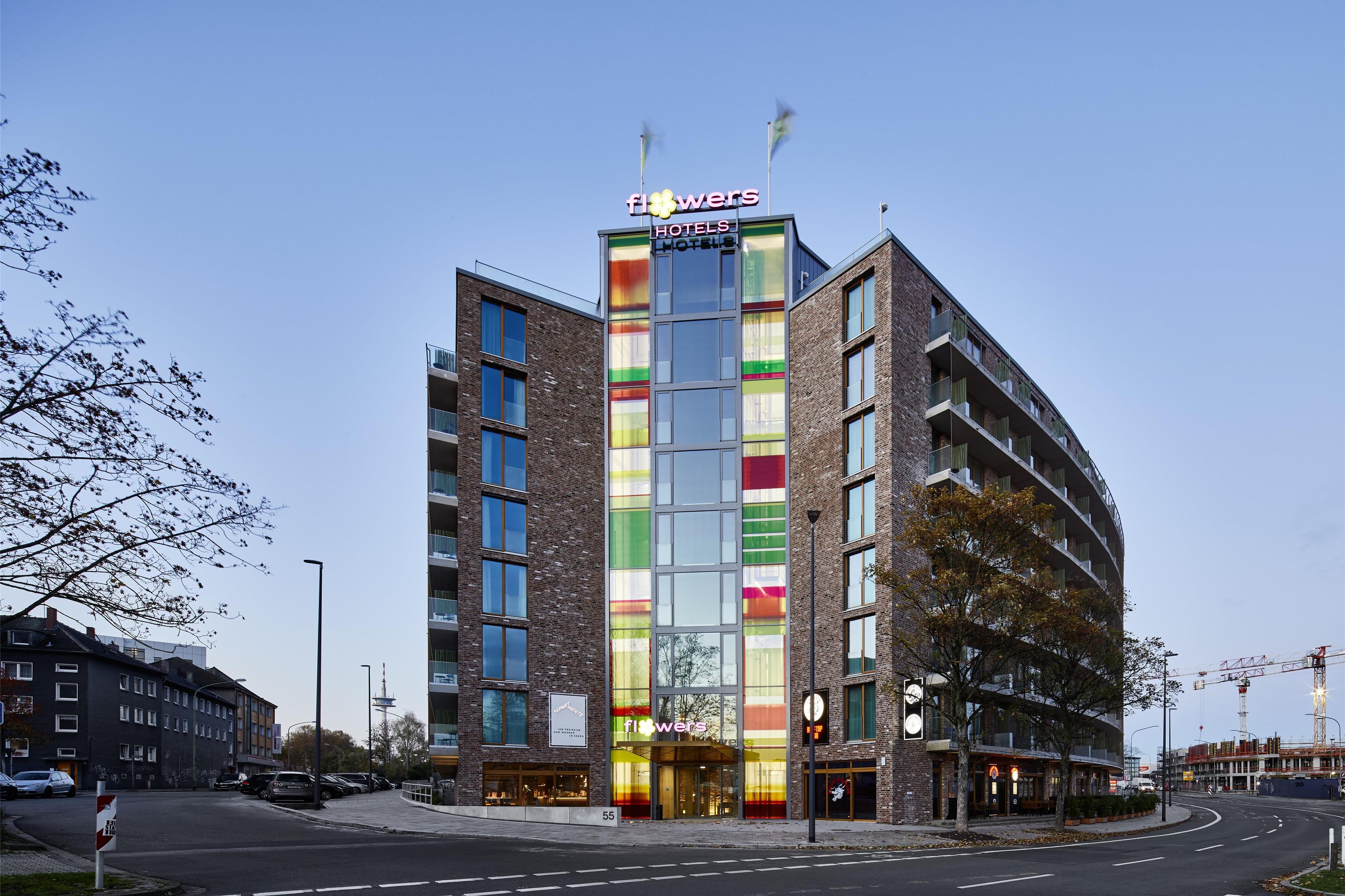 A modern hotel with a colorful facade, multiple floors, and a prominent entrance.
