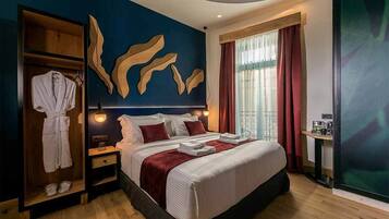 A hotel room with a large bed, a wardrobe, a vanity with a mirror, and a large window with curtains.
