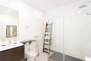 A modern bathroom with a glass shower enclosure, a white sink, and a patterned floor. - Excellent Location A/C and views in Principe Real (Lisboa)
