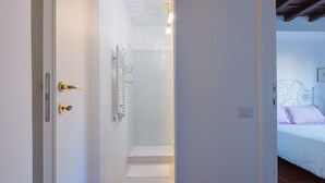 Une pièce avec un lit, une porte blanche et un espace douche.