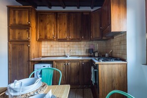 A kitchen with wooden cabinets, a sink, a stove, and a washing machine.