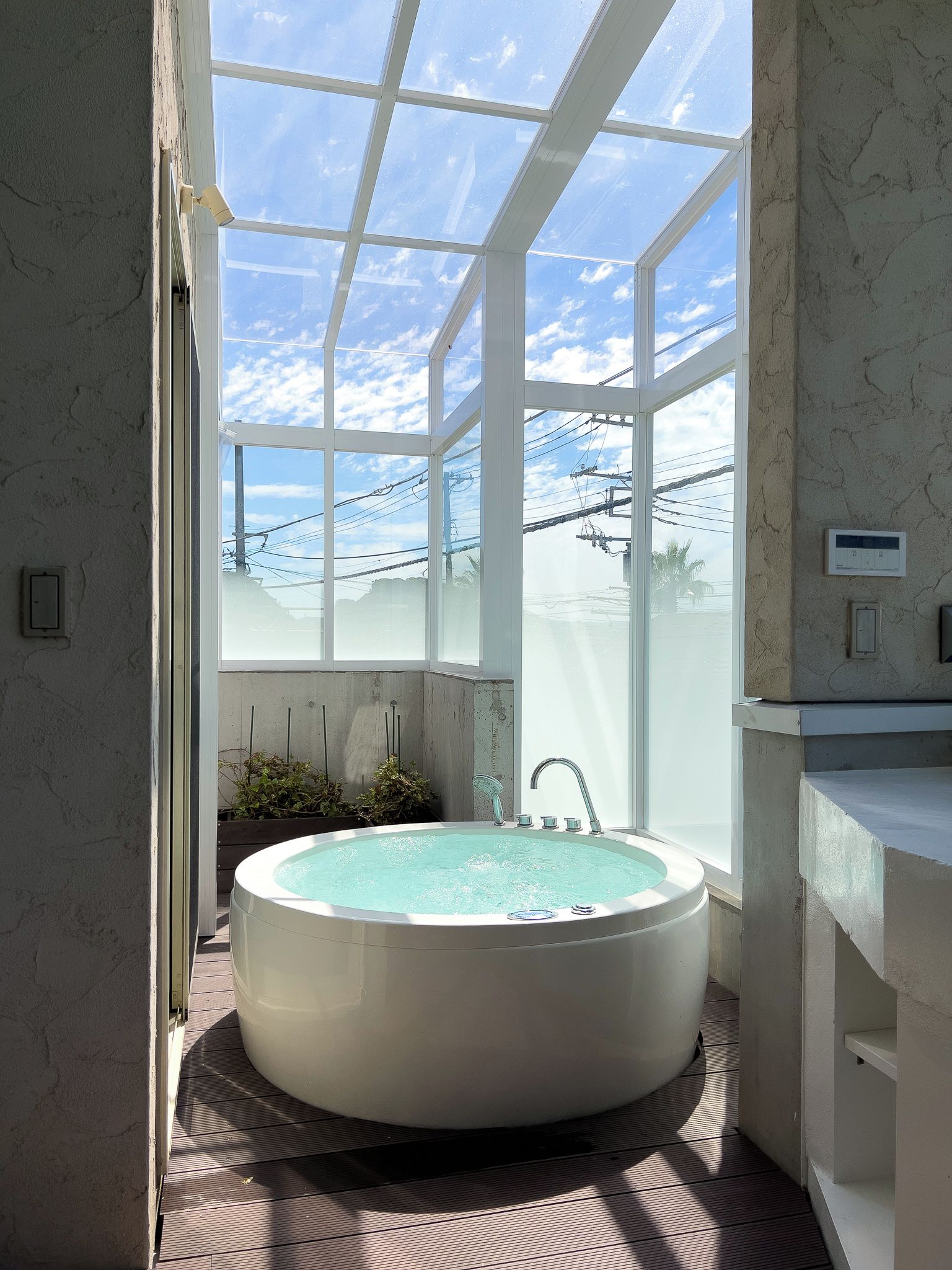Ein Badezimmer mit einer großen Badewanne, einem Fenster und Blick auf den Himmel.