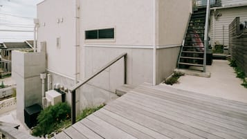 Ein modernes Gebäude mit einer Betonfassade, einer Holztreppe und einem Metallgeländer.